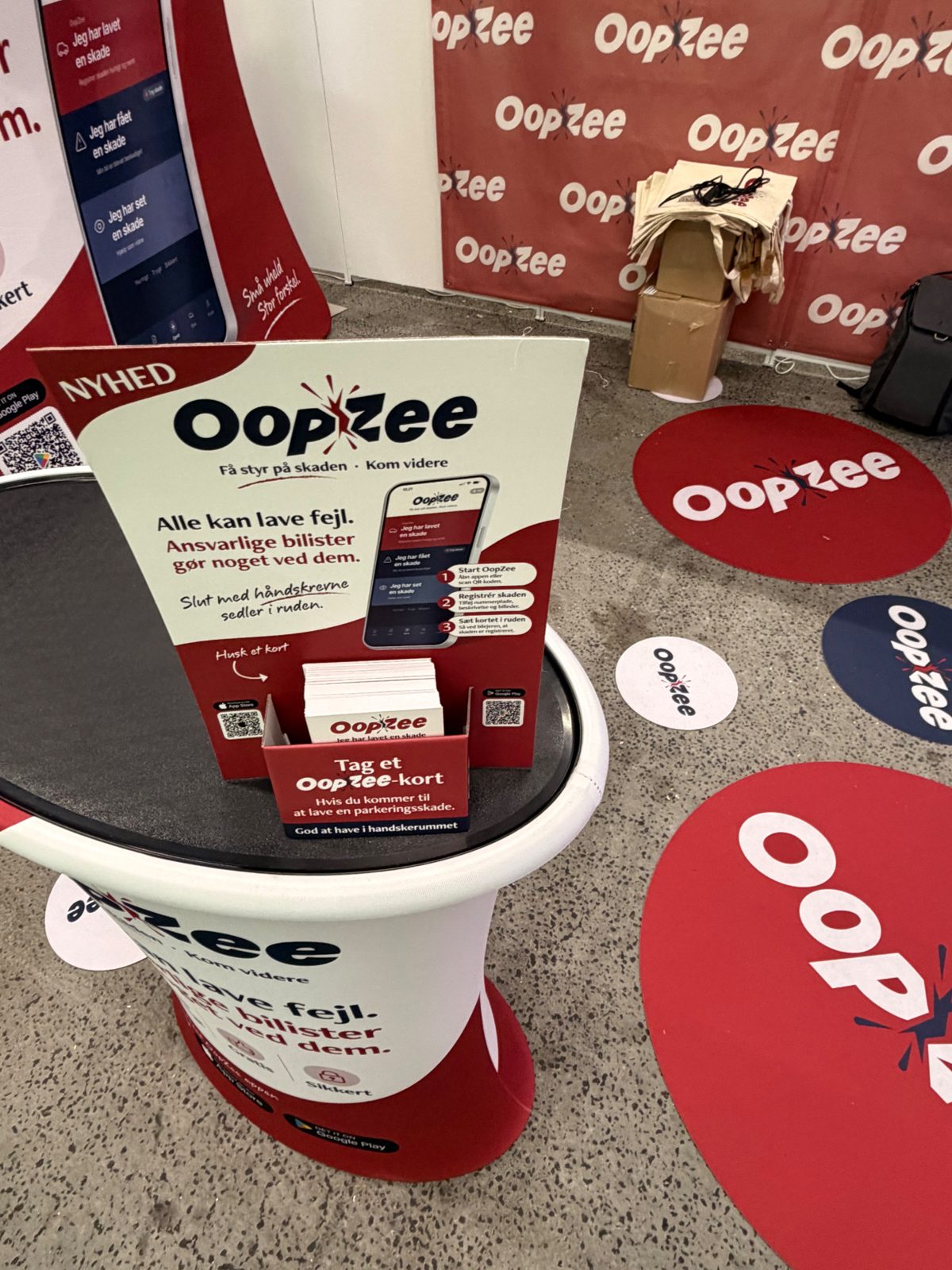 Bord med OopZee-display og kort, gulvmærker med OopZee-logo