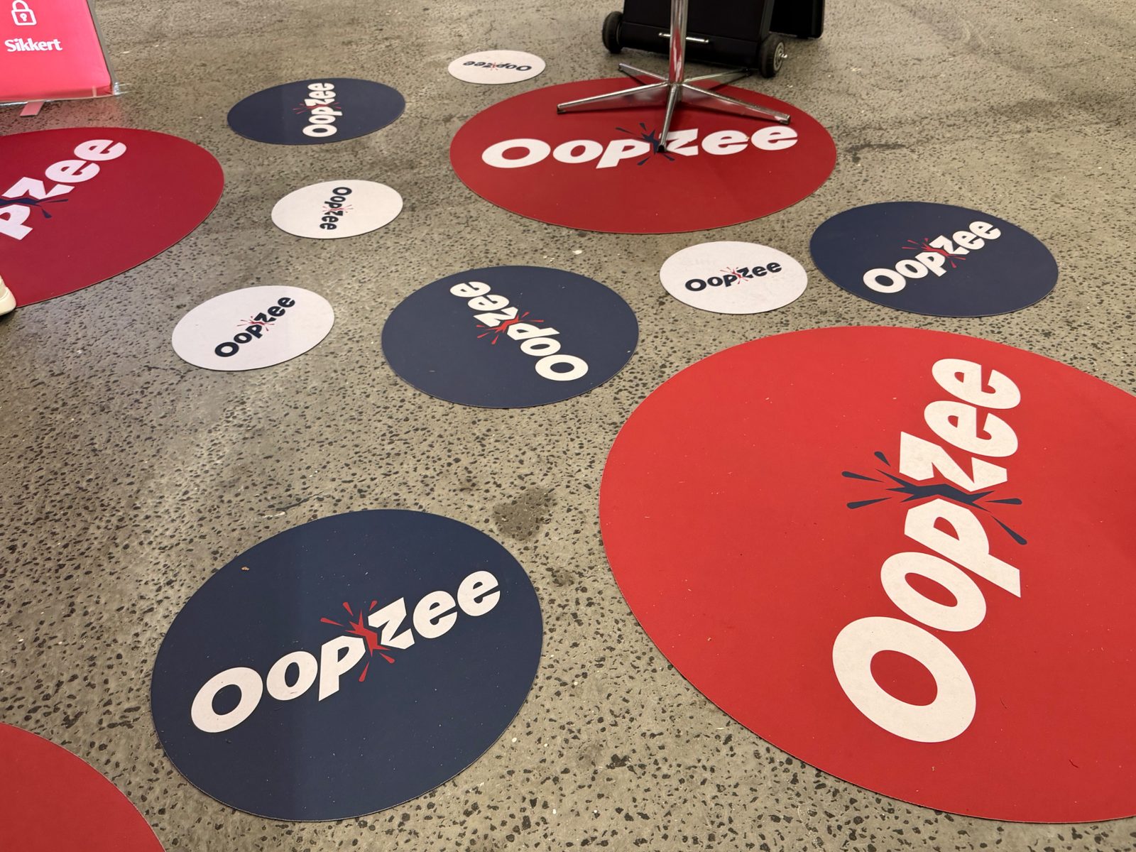 Gulvmærker i rødt, blåt og hvidt med OopZee-logoet