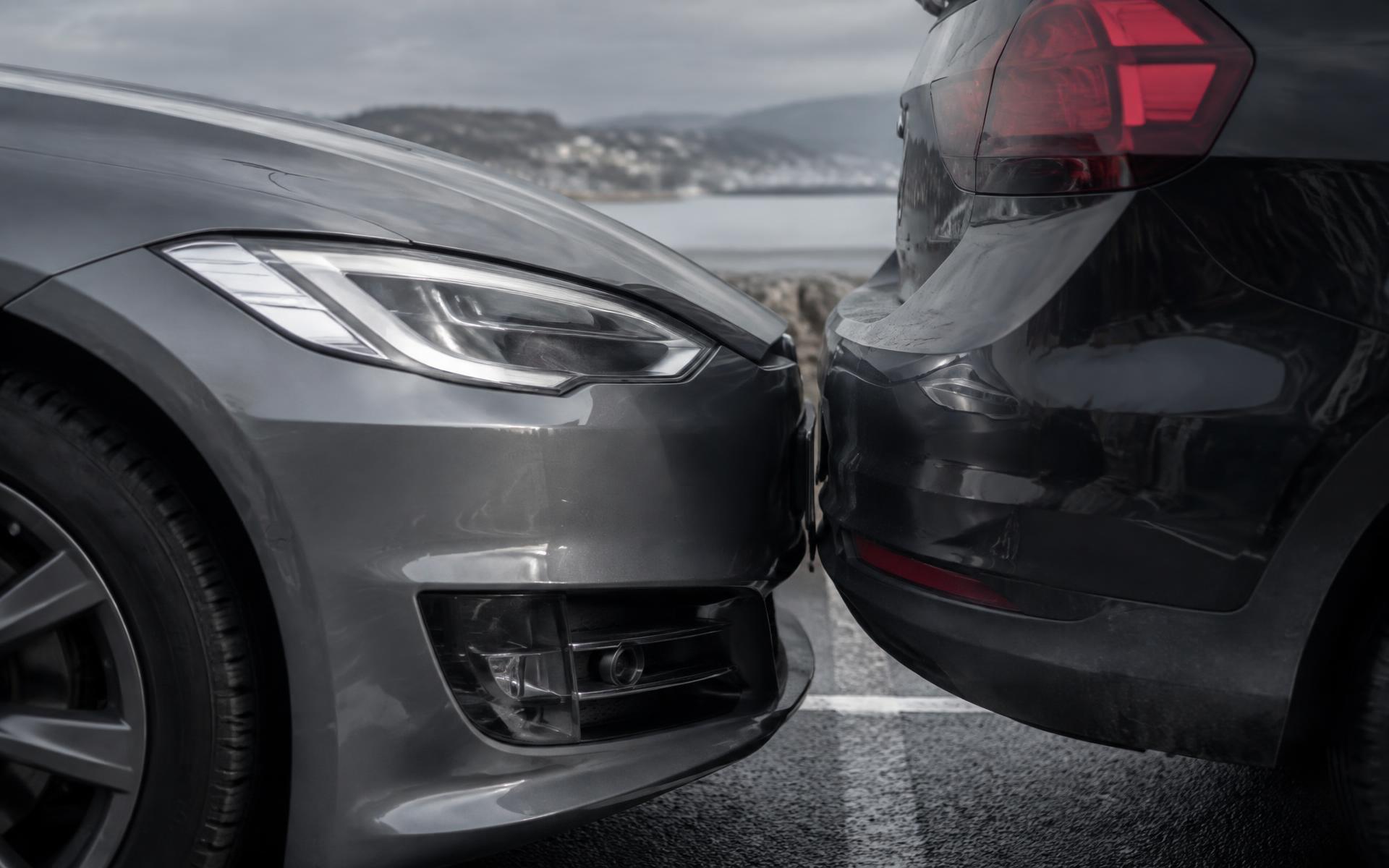 En bil rører let bagkofangeren på en parkeret bil på en parkeringsplads